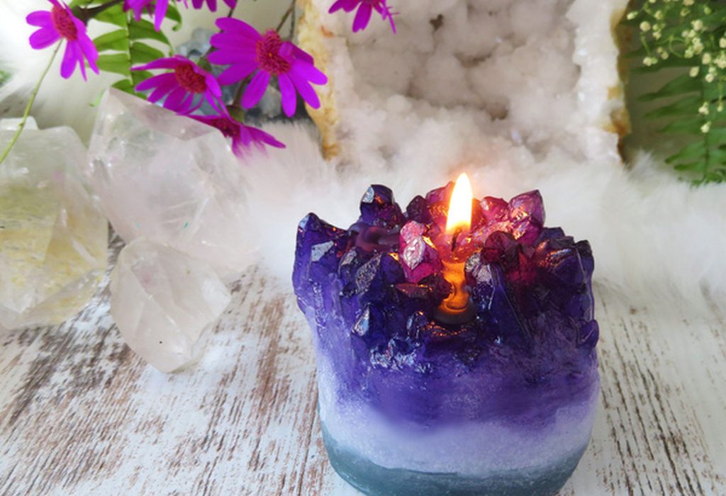 Velas artesanales de soja en tonos crema y cálidos con flores secas y eucalipto en un estudio acogedor.